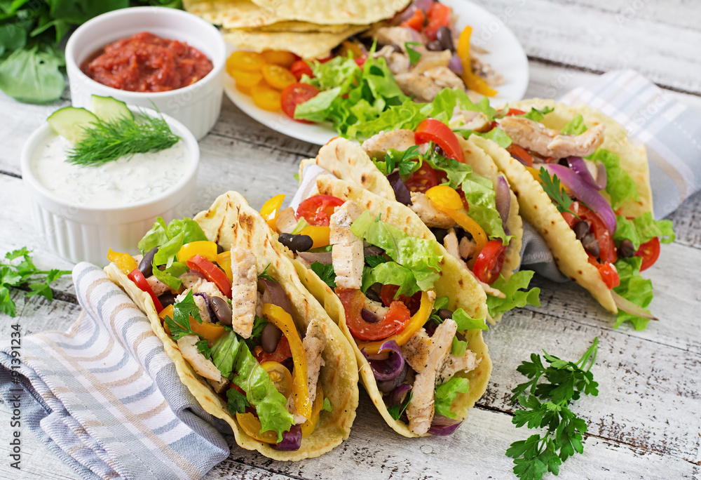 Mexican tacos with chicken, bell peppers, black beans and fresh vegetables. Mexican tacos with chicken, bell peppers, black beans and fresh vegetables.