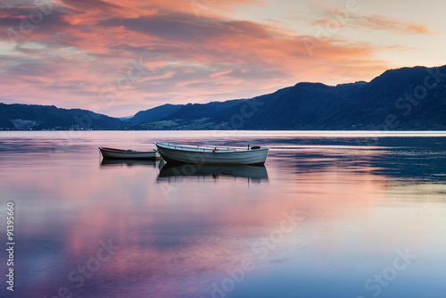 Two lonely boats on calm water of fjord. Norway.