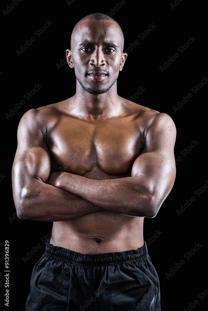 Portrait of shirtless muscular man standing with arms crossed