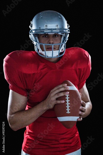 Portrait of confident sportsman with American football