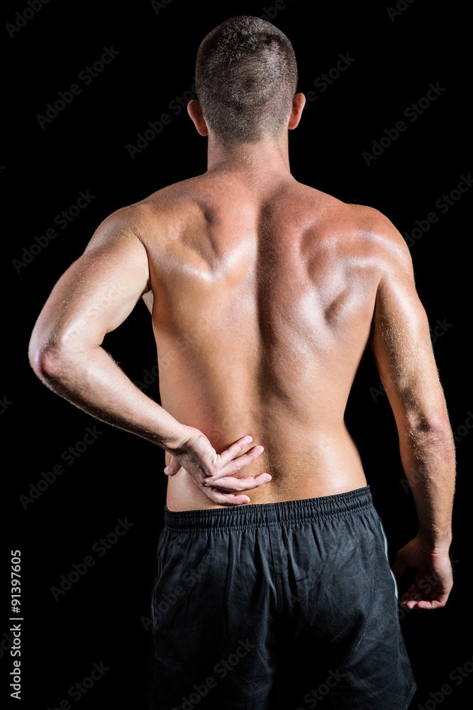Shirtless athlete with back pain