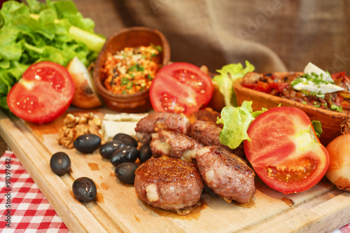 Meat burgers and vegetable.Stew in pot on wooden plank