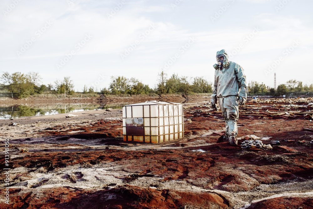 Man with gas mask and green military clothes explores barrels af Man with gas mask and green military clothes explores barrels af