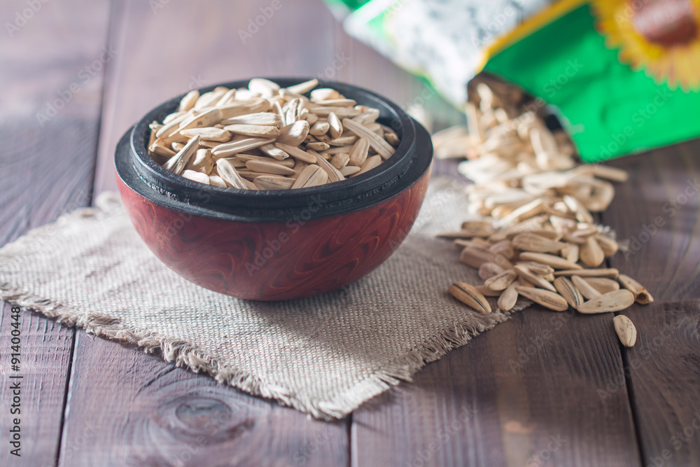 White sunflower seeds in wooden bowl White sunflower seeds in wooden bowl