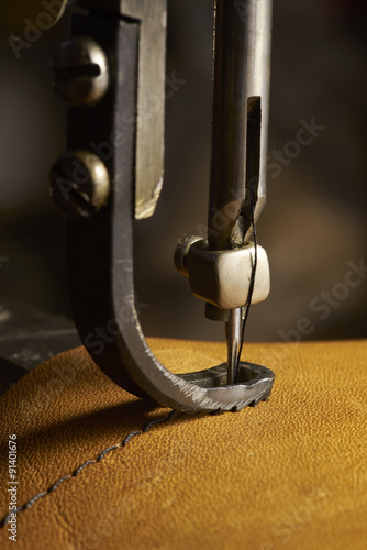 Closeup of sewing machine working part with leather