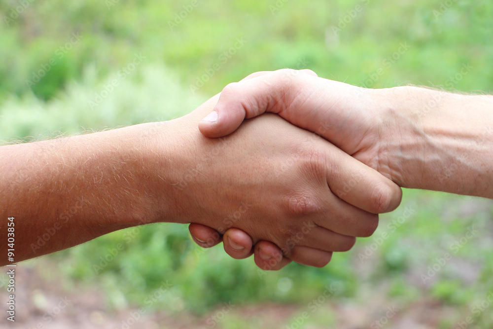 Suntanned male hands make handshake Suntanned male hands make handshake