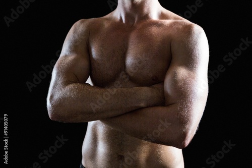 Shirtless muscular man with arms crossed