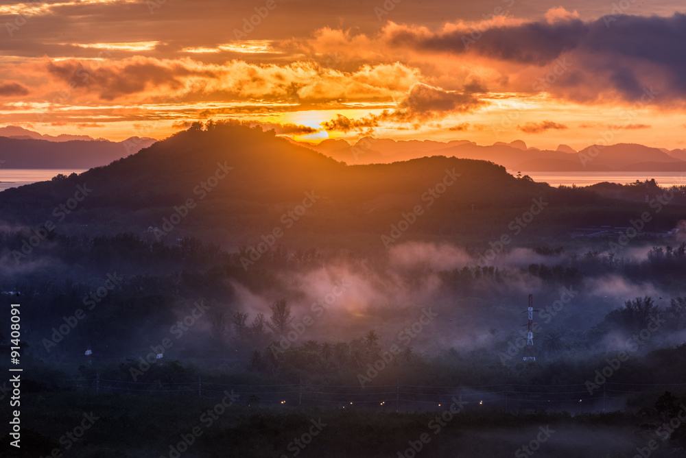 Fototapeta premium sunrise behind mountain and fog