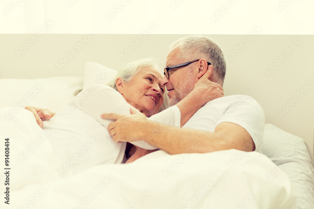 happy senior coupler lying in bad at home happy senior coupler lying in bad at home