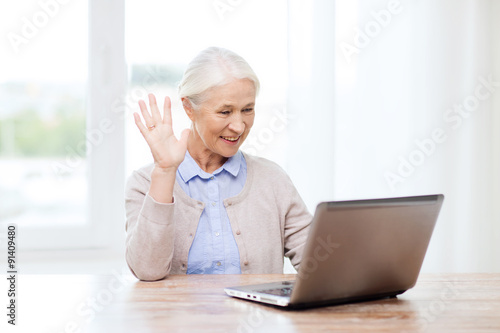 senior woman with laptop having video chat at home