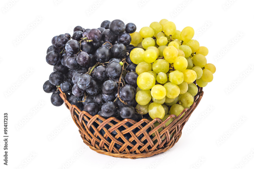 Ripe red and white grapes in woven basket isolated on a white Ripe red and white grapes in woven basket isolated on a white
