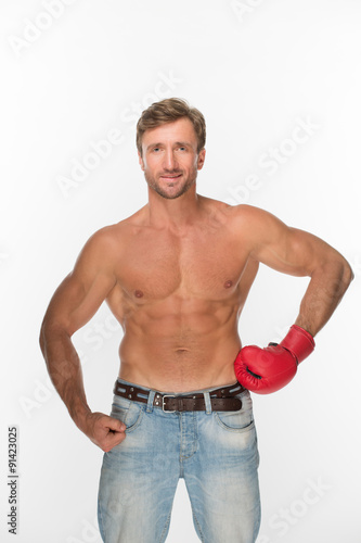Shirtless man with a boxing glove over white
