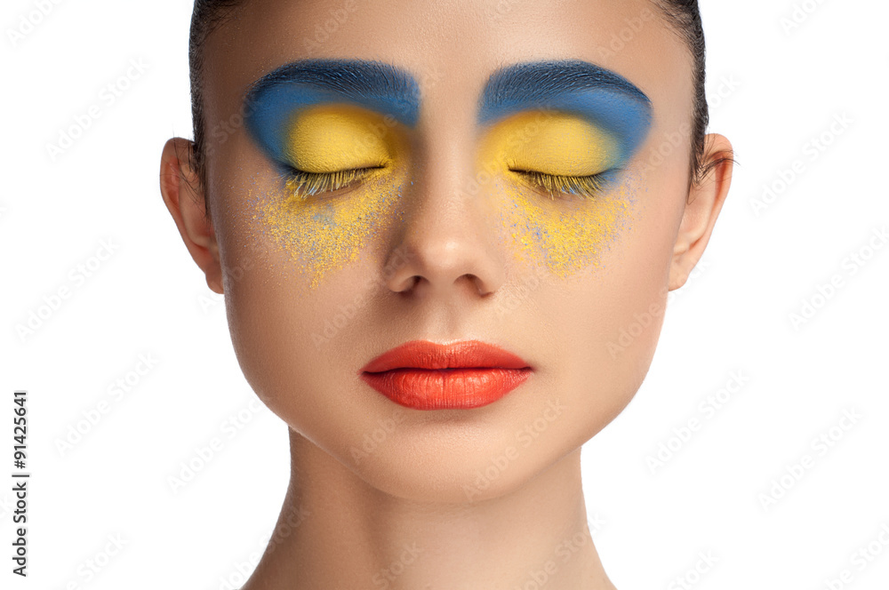 Naklejka premium High fashion look, closeup beauty portrait of beautiful young woman model with bright makeup with perfect clean skin with colorful red lips and blue yellow eyeshadows, blue yellow color. High key.