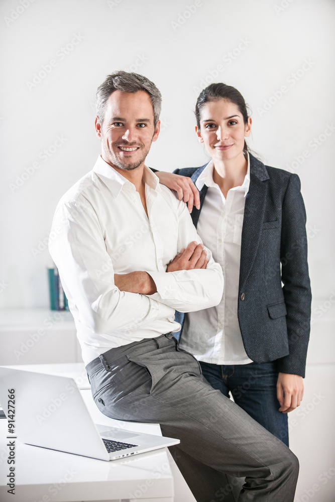 Portrait of two business associates in a luminous office. The ma Portrait of two business associates in a luminous office. The ma