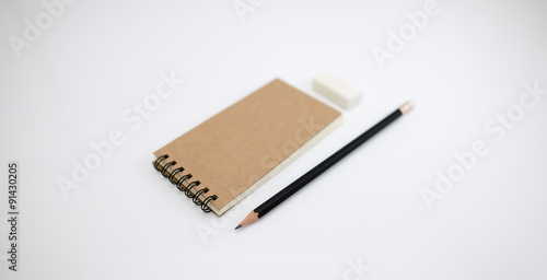 Brown cover notebook with pencil and eraser.