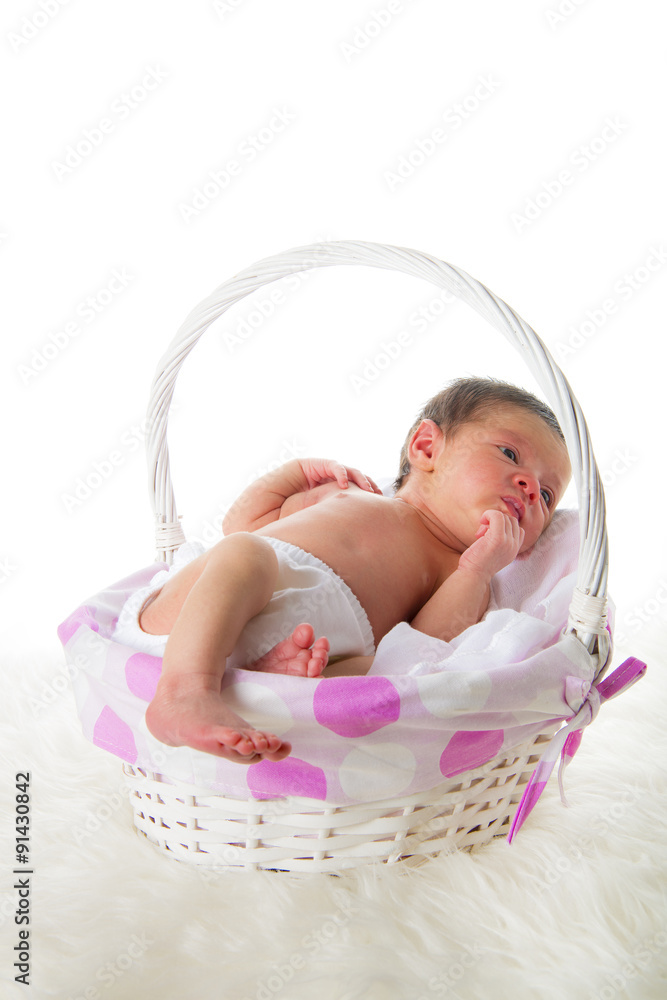 Bebé recién nacido niña relajada en calma dormida en una cesta blanca y  rosa sobre una manta de pelo Stock Photo