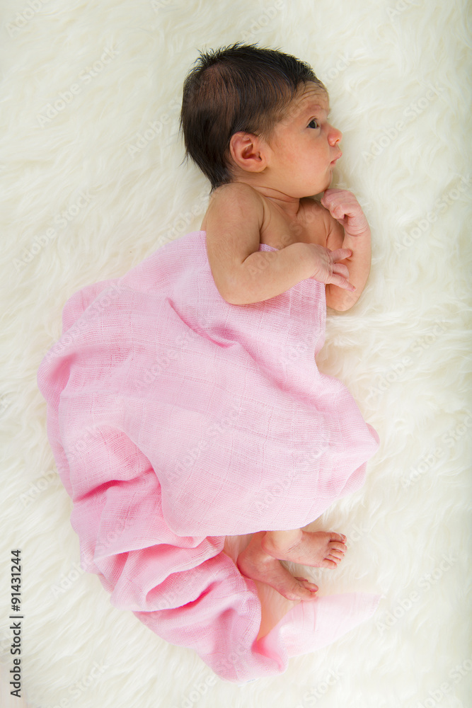 Niña bebé recién nacido en calma relajada sobre una manta de pelo
