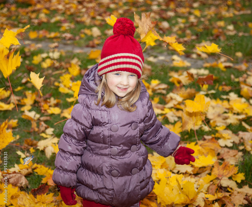 Beautiful little girl walking among autumn leaves Beautiful little girl walking among autumn leaves