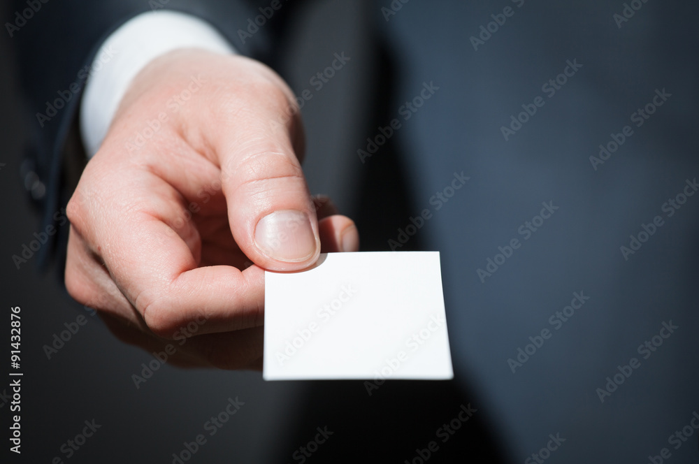 Man's hand reaching out a business card Man's hand reaching out a business card