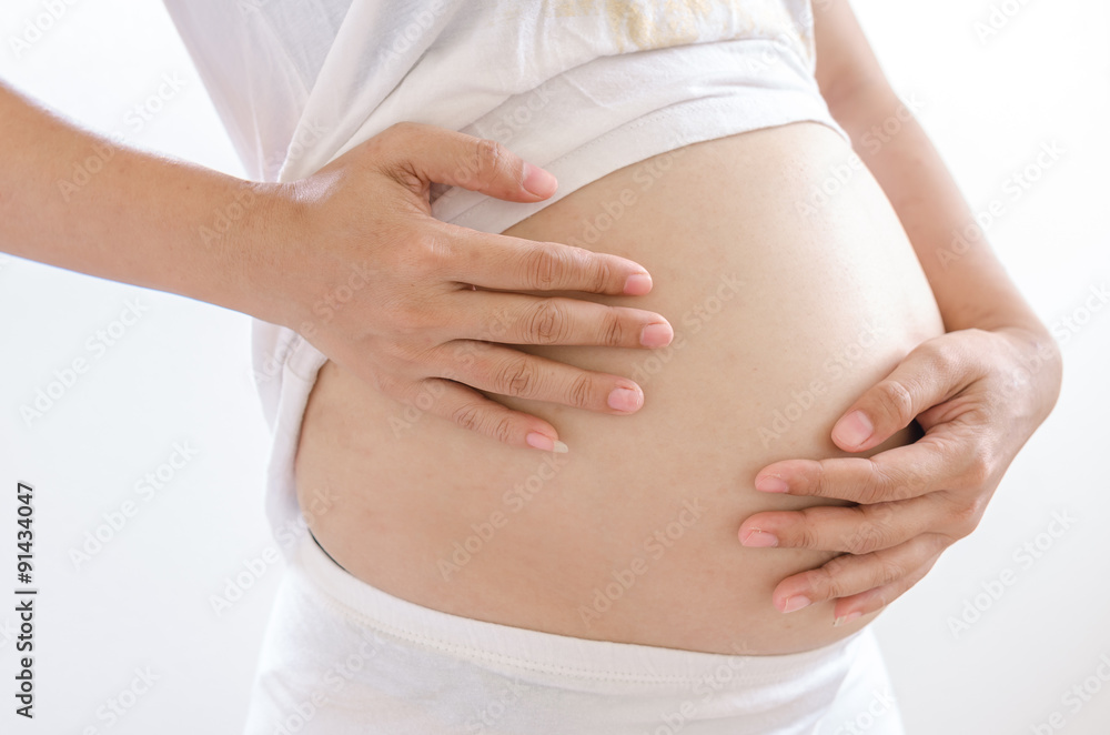 Close up pregnant women touching her belly with hands