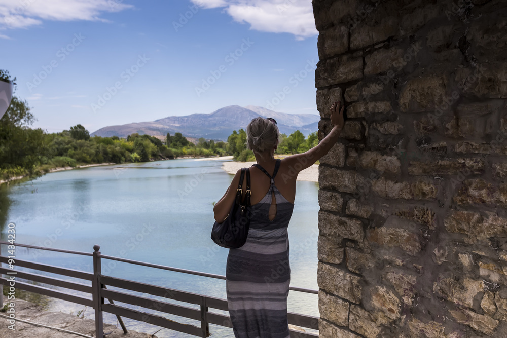 Woman standing on the bridge looking at the View of Arachthos ri