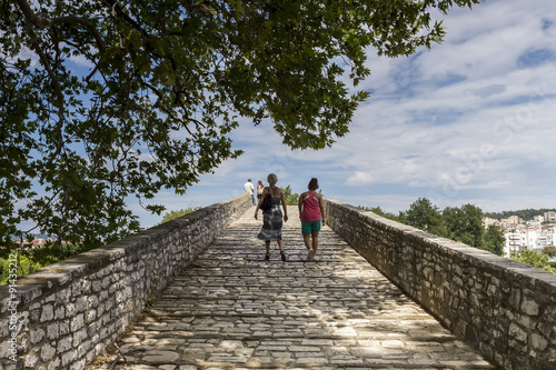 Women walking on the bridge looking at the View of Arachthos riv