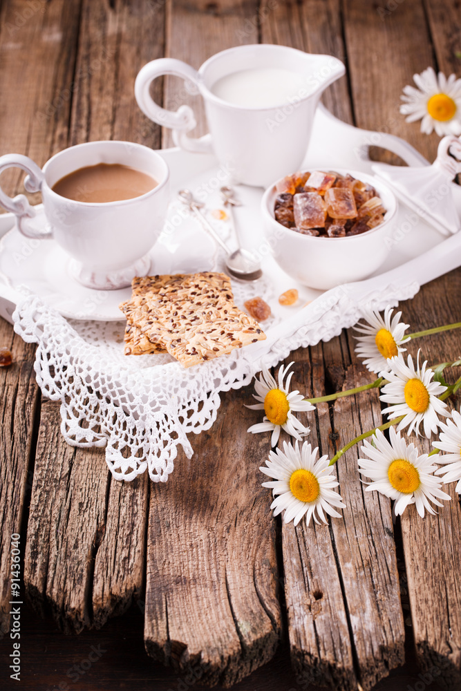 Fototapeta premium Coffee with milk and cookies on a tray. Romantic Breakfast with daisies.selective focus