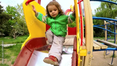 Happy Active Little Boy Sliding Down At Playground