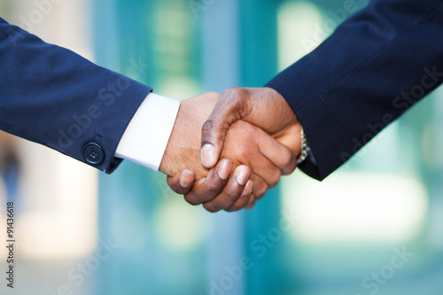  African businessman shaking hands with a caucasian one