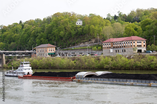 Tugboat Moving Barges Filled with Coal - White Tugboat Moving Barges Filled with Black Coal on the Ohio River