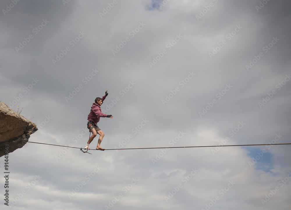 A man walks down slackline. A man walks down slackline.