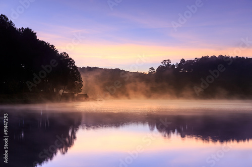 Beautiful foggy sunrise on a lake
