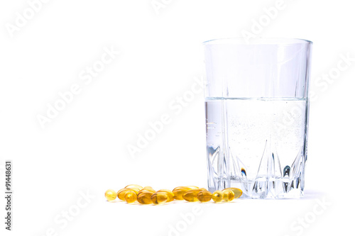 Medicine pills or capsules heart shaped with glass of water