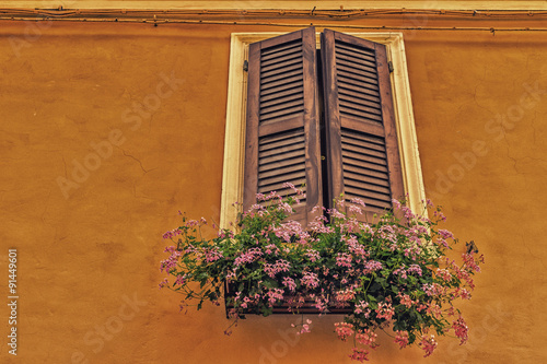 window with wooden shutters and  geraniums