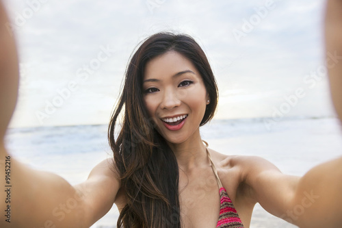 Asian Woman Girl at Beach Taking Selfie Photograph © Darren Baker