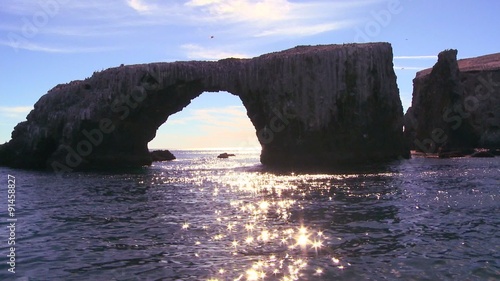 Sunlight sparkles on the sea by Anacapa Island's iconic natural bridge in Channel Islands National Park. photo