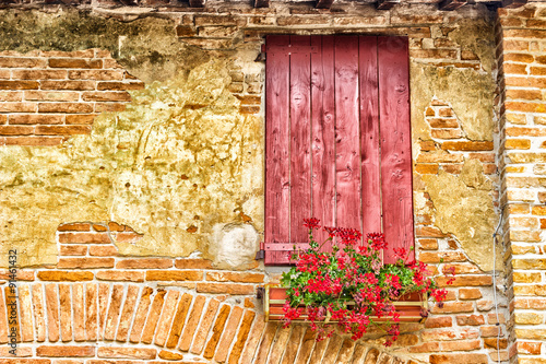 red window of country mill with shutters