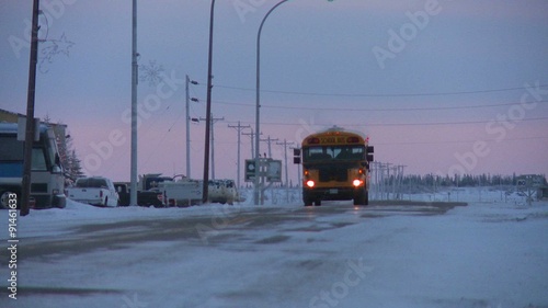 A school bus travels along an icy snowy road at Churchill, Manitoba, Canada, Hudson Bay.