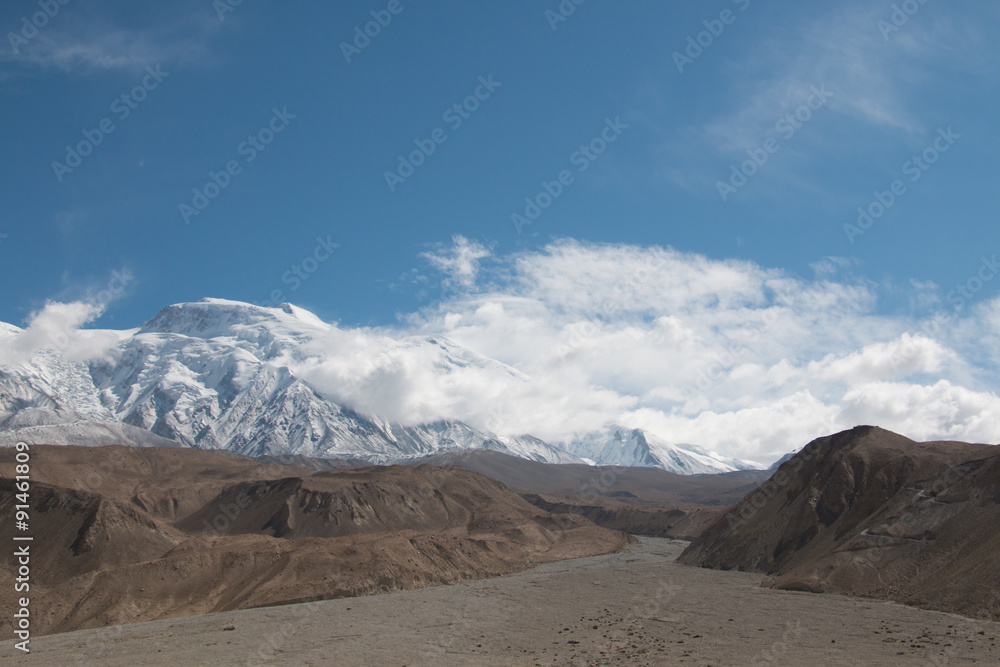 Empty riverbed with snow mountain and blue sky on a sunny day