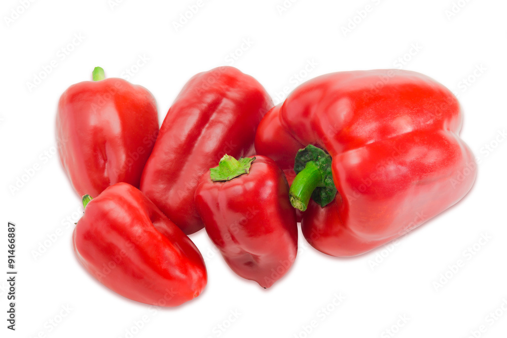 Several red bell peppers different sizes on a light background