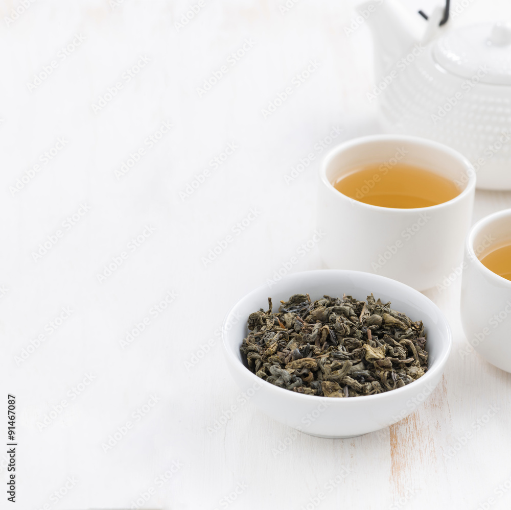 white wooden background with teapot and cups of green tea white wooden background with teapot and cups of green tea