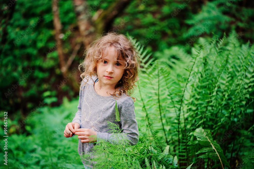 cute child girl exploring nature in summer forest near wild ferns cute child girl exploring nature in summer forest near wild ferns