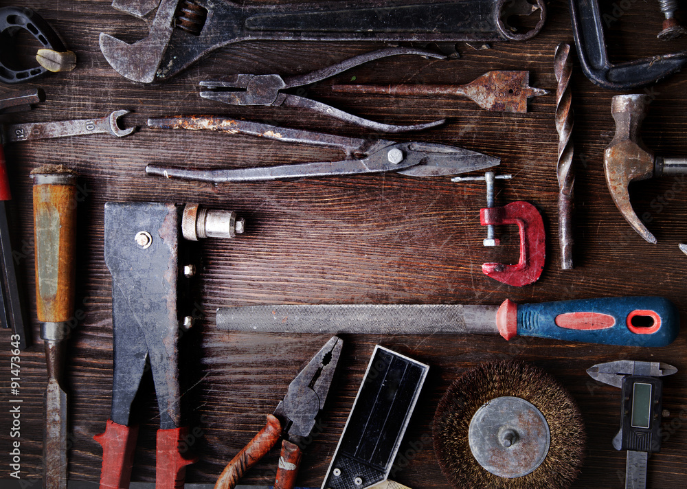 grungy old tools on a wooden background grungy old tools on a wooden background