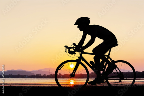 Fototapeta Naklejka Na Ścianę i Meble -  Man cycling at the beach twilight time