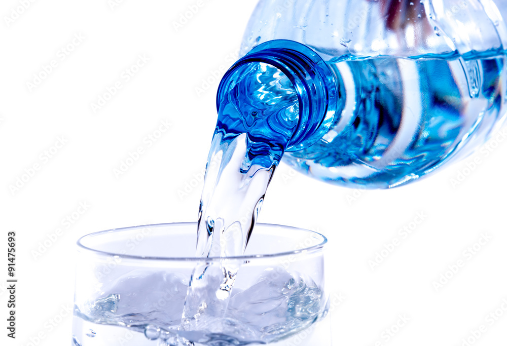 Water poured from a plastic bottle into a glass Water poured from a plastic bottle into a glass