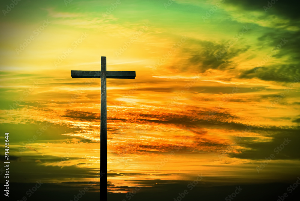Christian cross on green and yellow sunset background