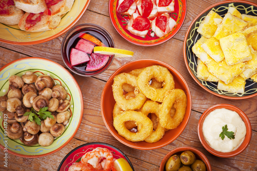 Assortment of Spanish tapas and sangria on a rustic table Assortment of Spanish tapas and sangria on a rustic table