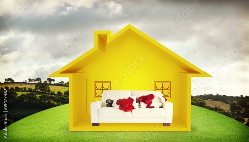 Composite image of father christmas sleeps on a couch photo