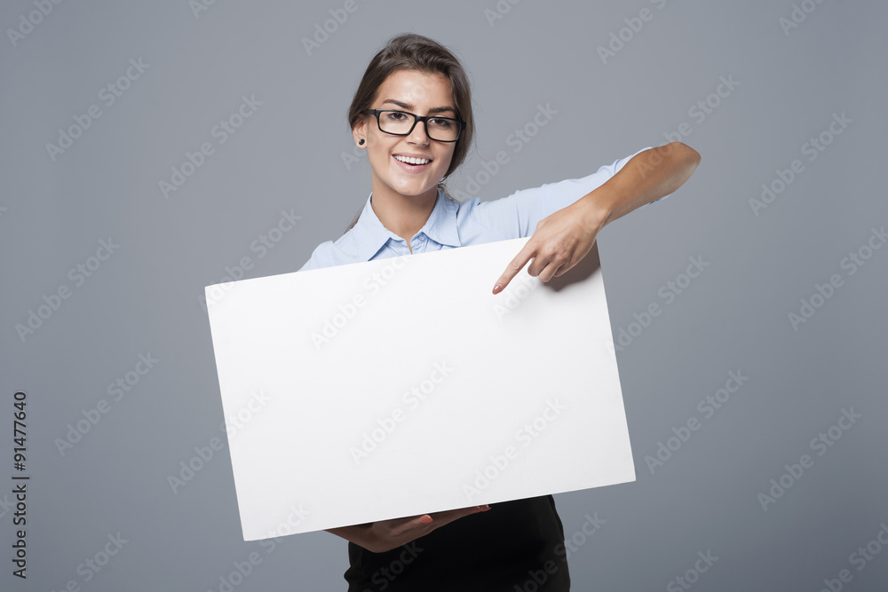 Beautiful businesswoman showing on empty whiteboard Beautiful businesswoman showing on empty whiteboard