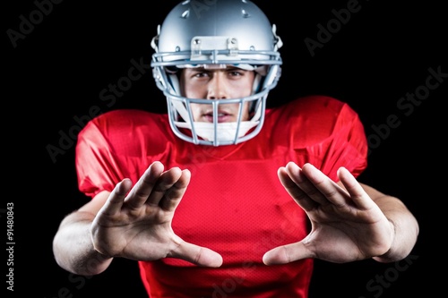 Portrait of sportsman defending while playing American football